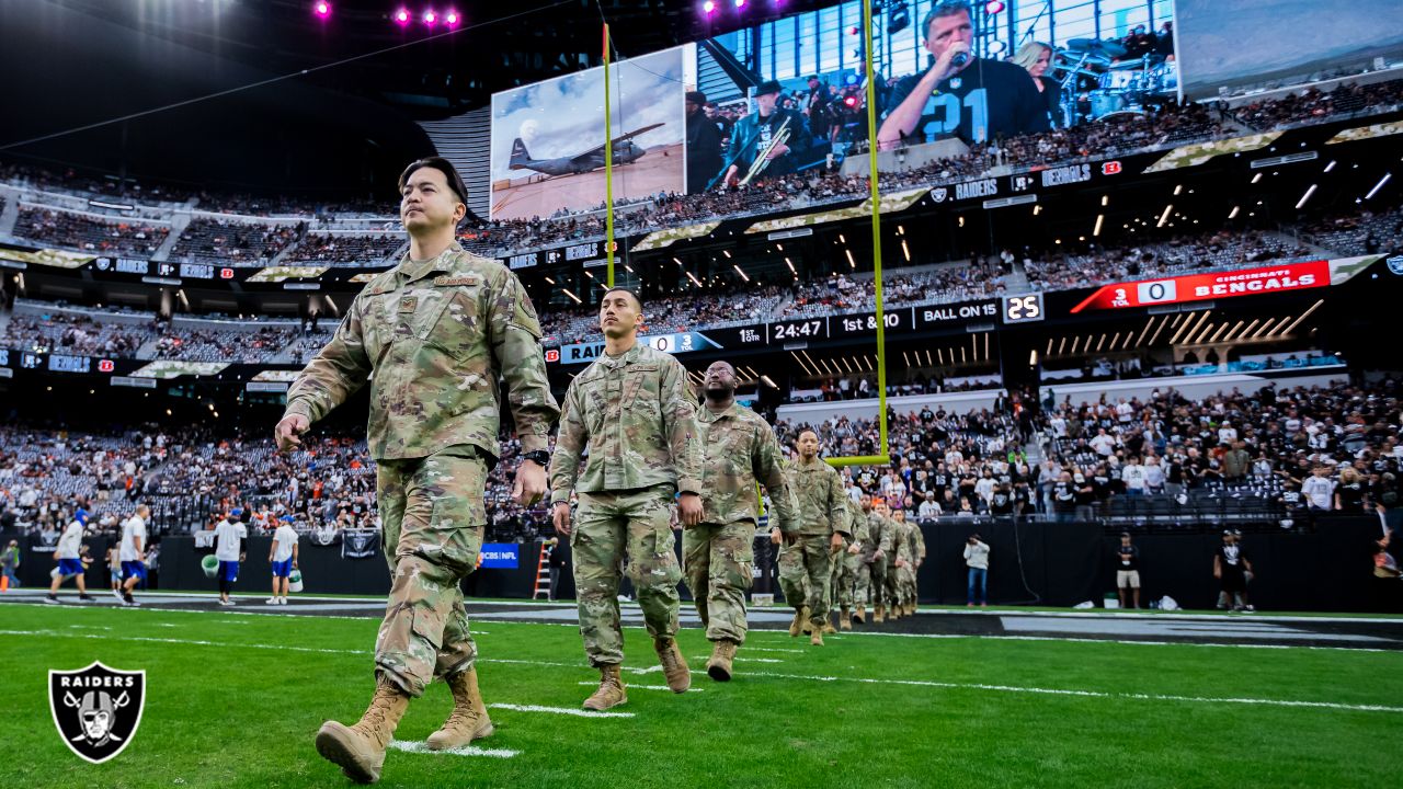 Service members from all five branches of the armed services carry a large  American flag out onto the field at the Salute to Service Chicago Bears  game Nov. 27 at Soldier Field