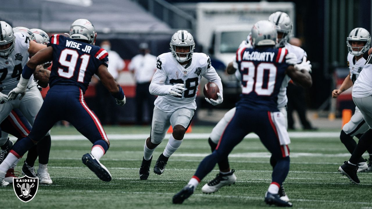 Las Vegas Raiders running back Josh Jacobs (28, left) jokes around with  head coach Jon Gruden d …