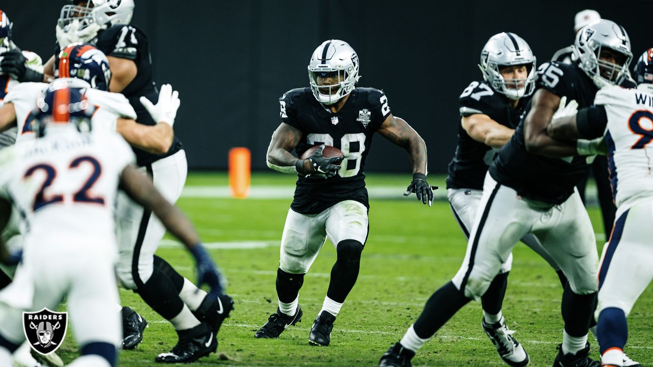 Las Vegas Raiders running back Josh Jacobs (28, left) jokes around with  head coach Jon Gruden d …