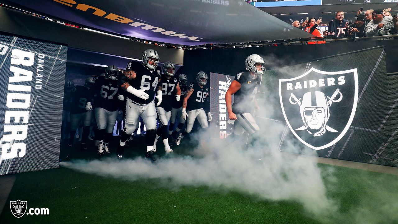 Fans wave team flags at an NFL game between the Oakland Raiders and the  Chicago Bears at Totten …