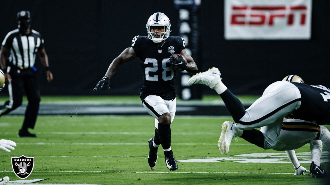 Las Vegas Raiders running back Josh Jacobs (28, left) jokes around with  head coach Jon Gruden d …