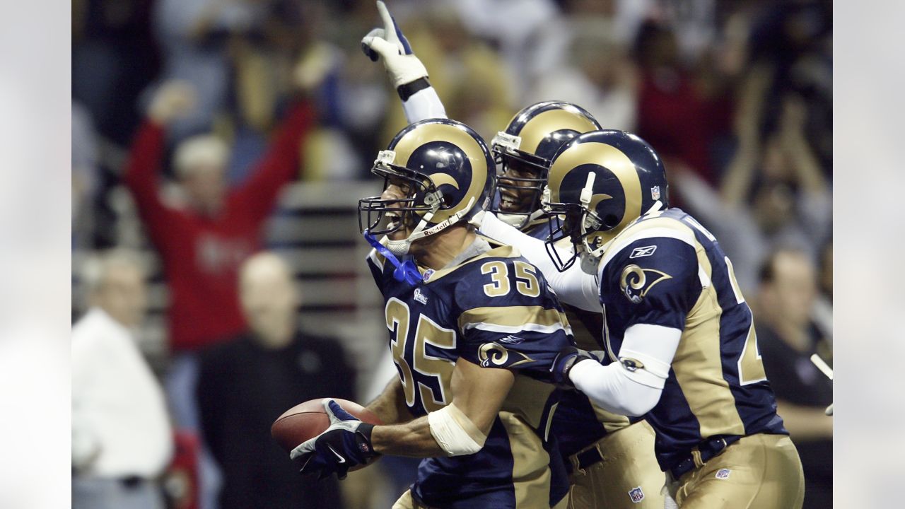 St. Louis Rams' Aeneas Williams, holds his son, Lazarus, as he celebrates  the Rams' 29-24 victory over the Philadelphia Eagles in the NFC  Championship game Sunday, Jan. 27, 2002 in St. Louis. (