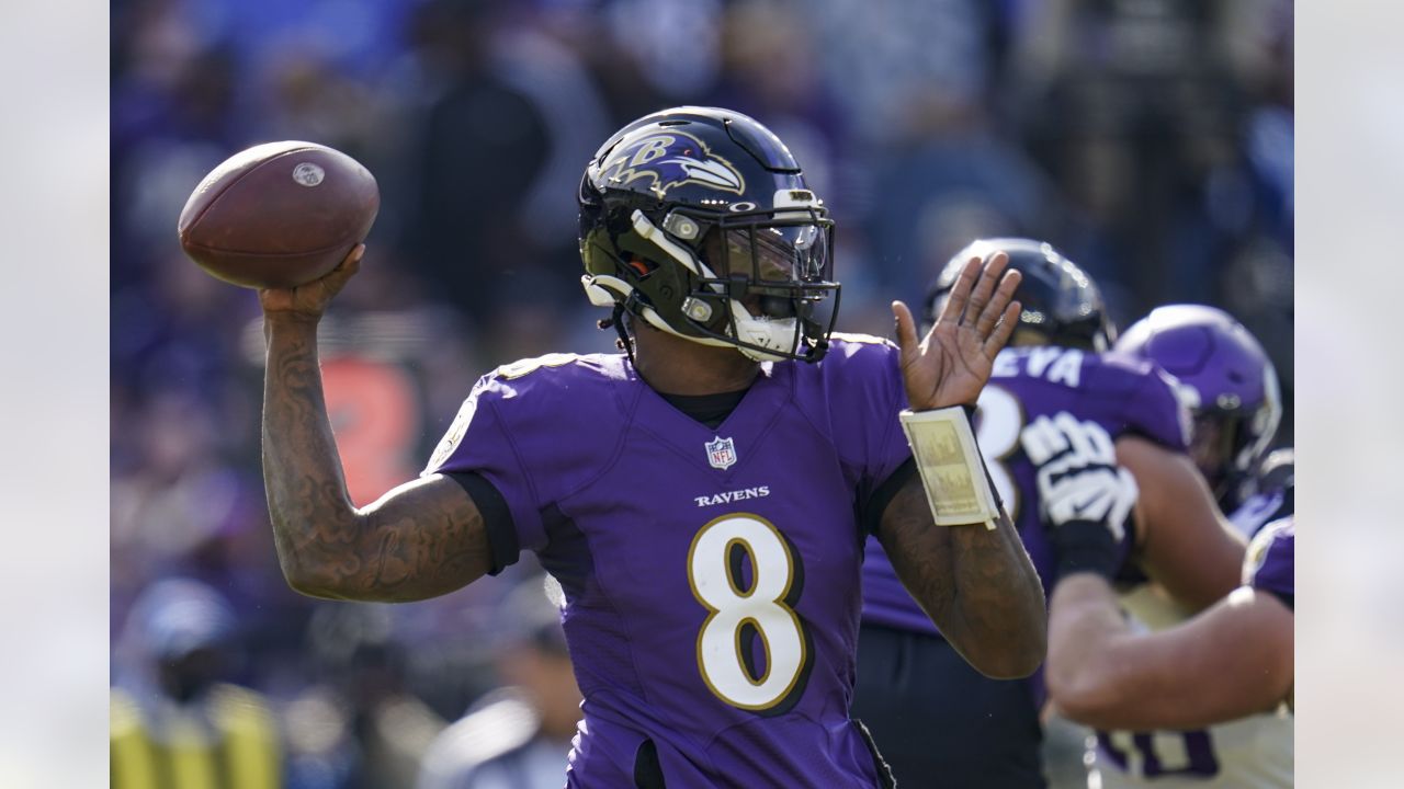 Baltimore Ravens quarterback Lamar Jackson (8) takes to the field with a  member of the military as part of Salute to Service before an NFL football  game against the Carolina Panthers, Sunday