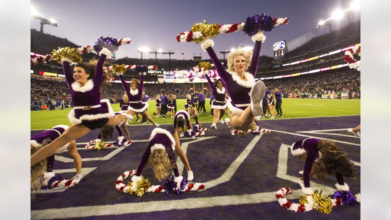 Photo: A Packers cheerleader waves pom poms against the Ravens in