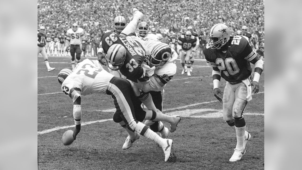 Tony Dorsett (33) of the Dallas Cowboys tries to break a tackle by the  Philadelphia Eagles at Texas Stadium, Sunday, Dec. 27, 1982, Irving, Tex.  The Cowboys were only able to rush