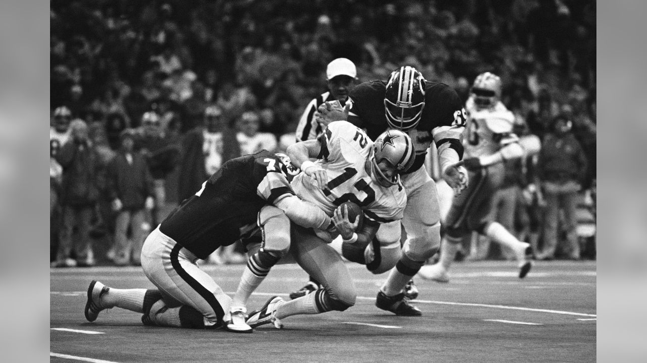 Dallas Cowboys quarterback Roger Staubach (12) looks for a receiver during  the NFC Championship game against the Washington Redskins at RFK Stadium in  Washington, DC on December 31, 1972. Blocking for Staubach