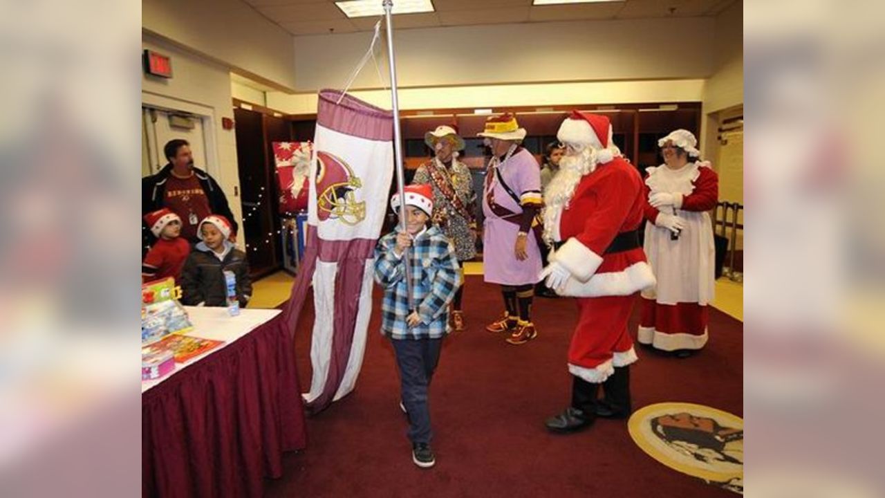 A Washington Redskins cheerleader performs in a Santa Claus costume,  holding a gift during a break in the NFL action between the Redskins and  the Dallas Cowboys, at FedEx Field, Landover Maryland