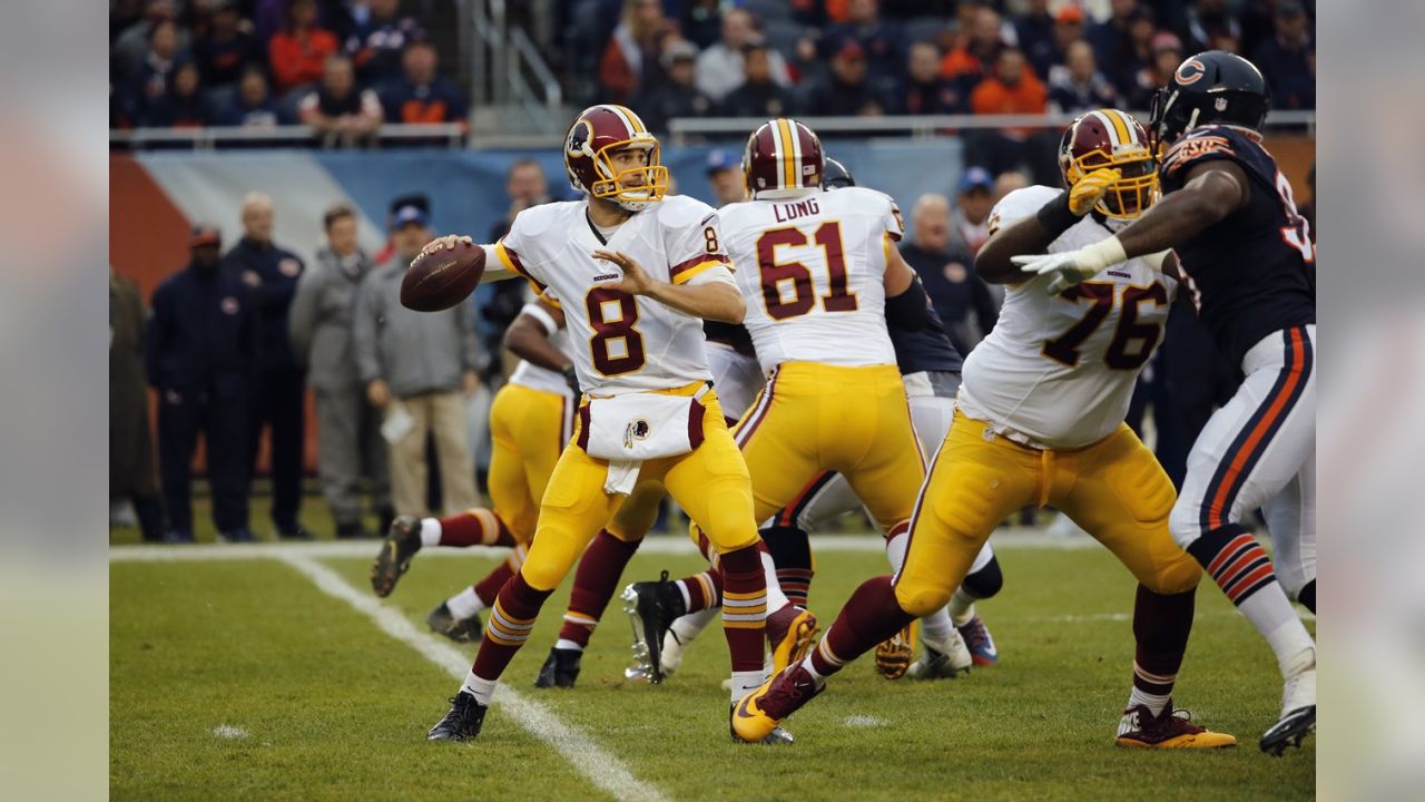 Quarterback Jay Cutler hoists the ball in the air as he runs for a