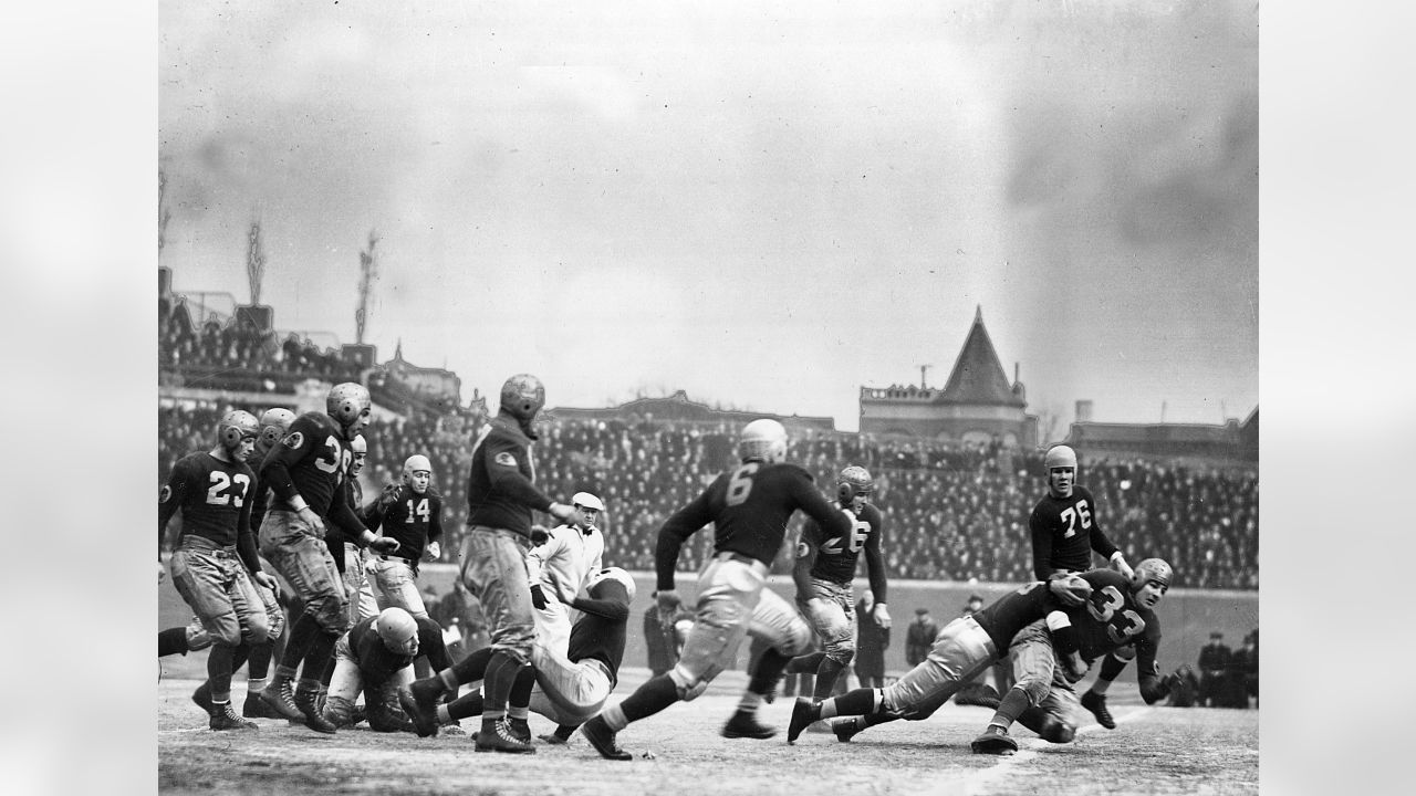 Los Angeles running back Marcus Allen (32) tries to break away from  Washington Redskins Dave Butz (65) as Rich Milot (57) looks on during the  first half of their game at R.F.K.