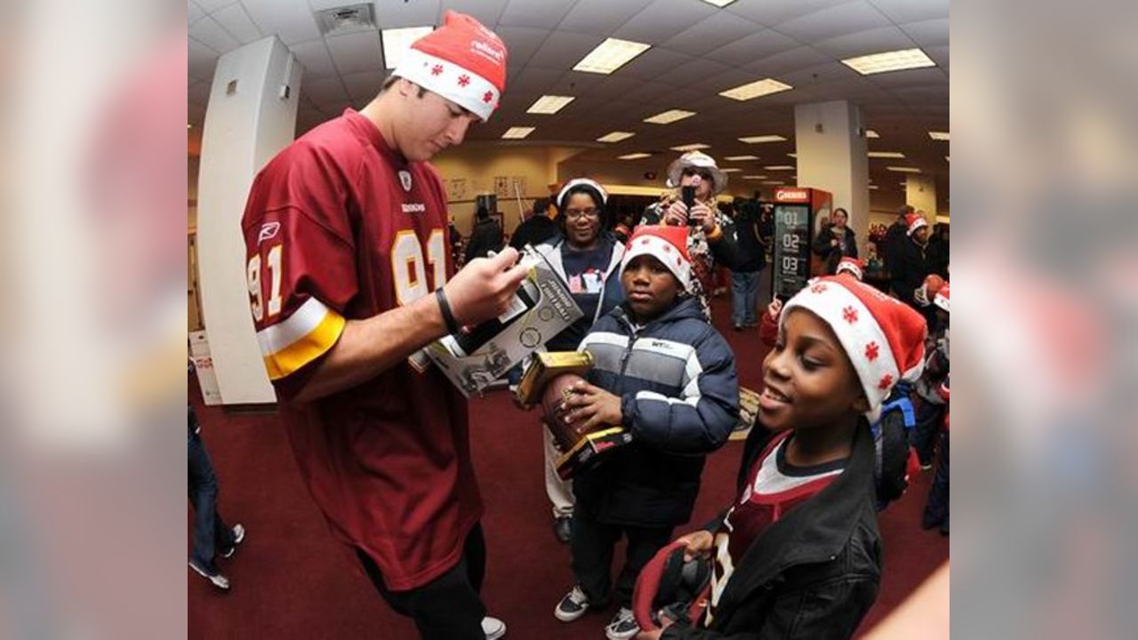 A Washington Redskins cheerleader performs in a Santa Claus costume,  holding a gift during a break in the NFL action between the Redskins and  the Dallas Cowboys, at FedEx Field, Landover Maryland