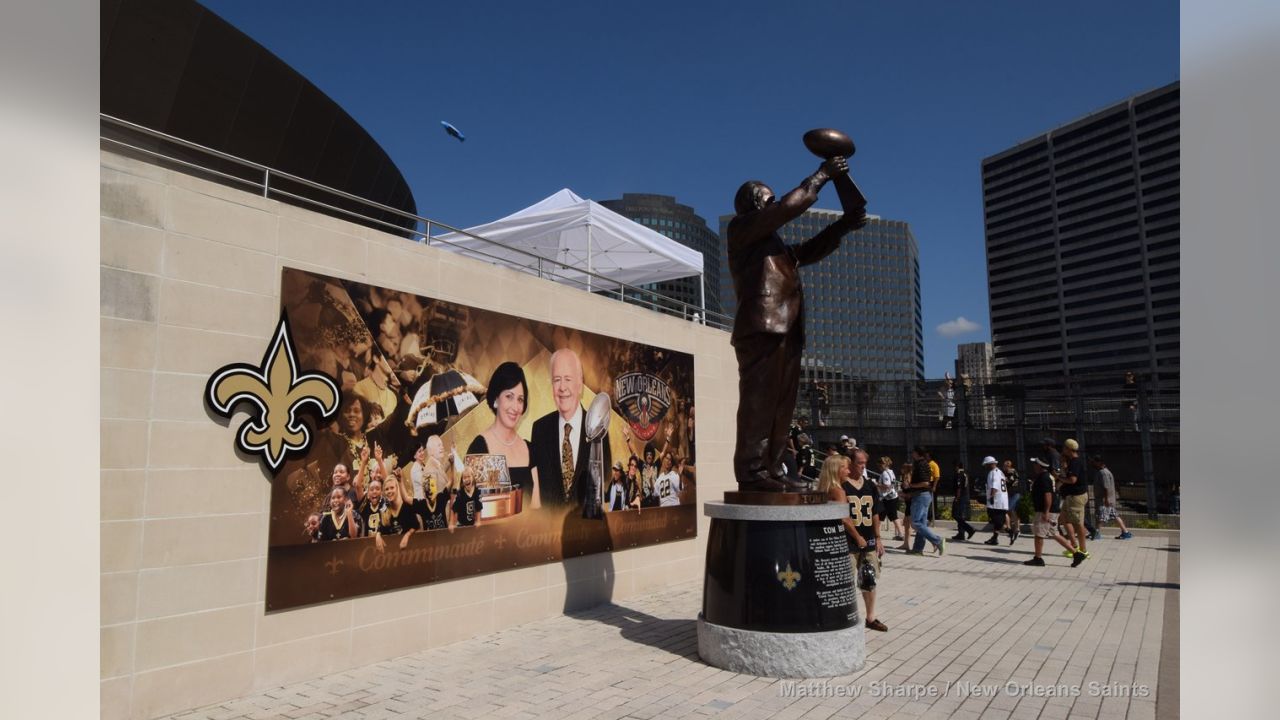 What's the story behind the Tom Benson statue outside the