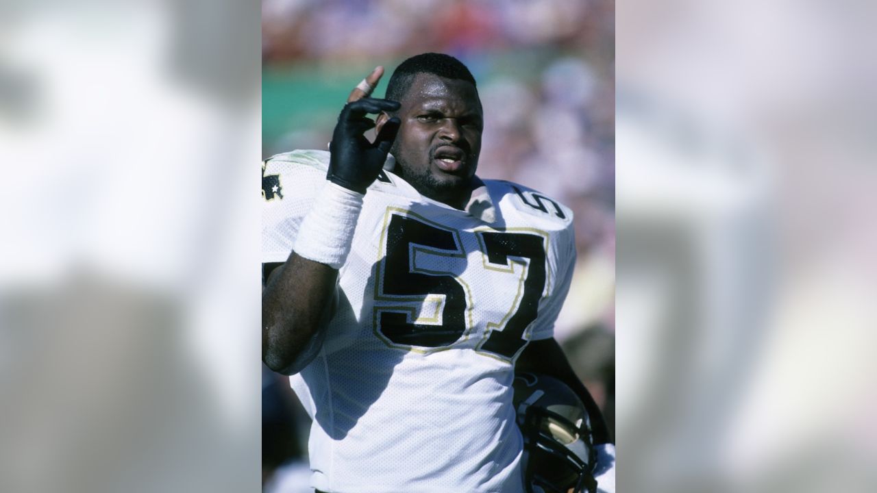 New Orleans Saints linebacker- Pat Swilling arounds around C. Miller-Press  Photo