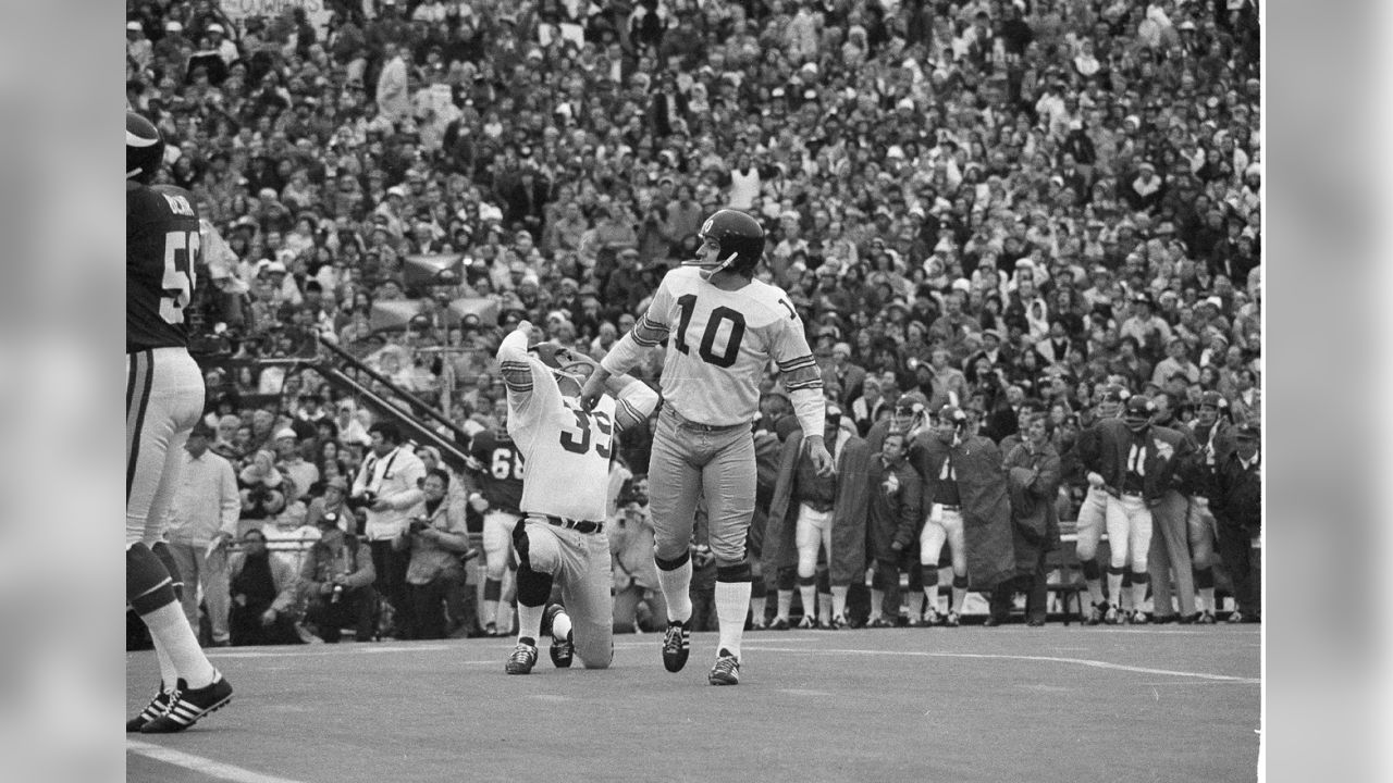 Terry Bradshaw tip-toes over a plank to avoid the flooded field at Tulane  Stadium just two days before their victory over the Vikings in Super Bowl IX  - 1975 : r/steelers