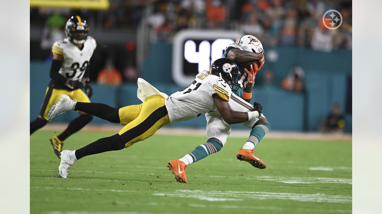 Mike Gesicki of the Miami Dolphins is tackled by Myles Jack of the