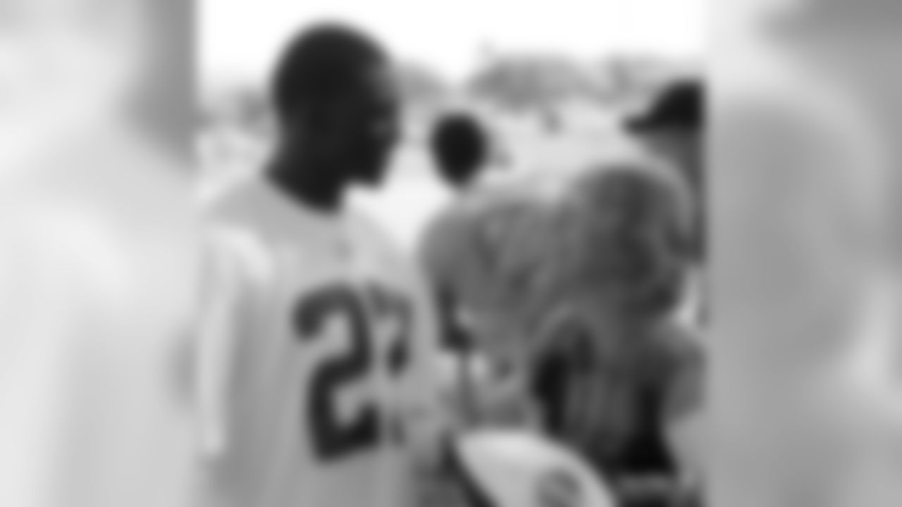 Walt Harris talks to a fan after practice