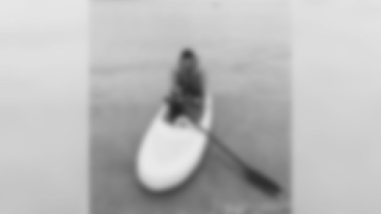 Staley getting a paddle boarding lesson from his daughter