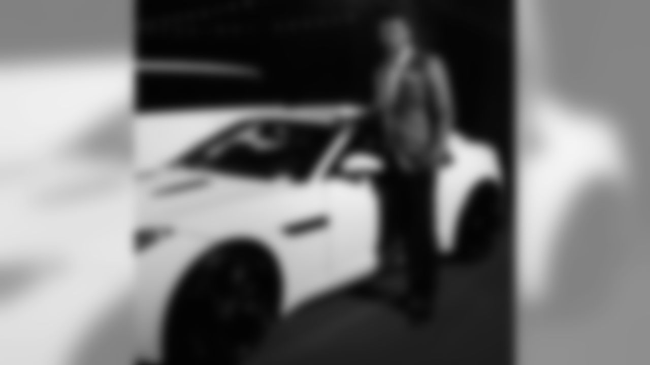 Colin Kaepernick poses next to his Jaguar.