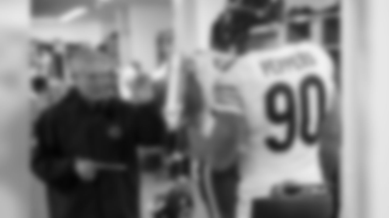 Legendary Bears strength coach Clyde Emrich high-fives defensive end Julius Peppers.