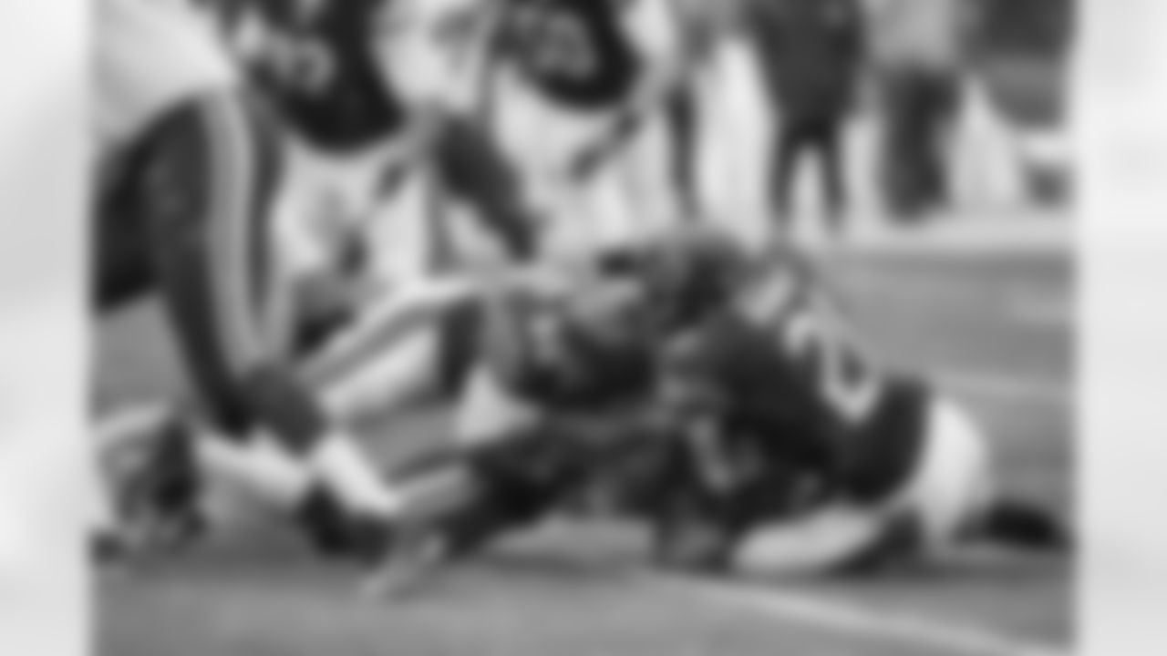 LB D.J. Williams and FS Ryan Mundy make a tackle.