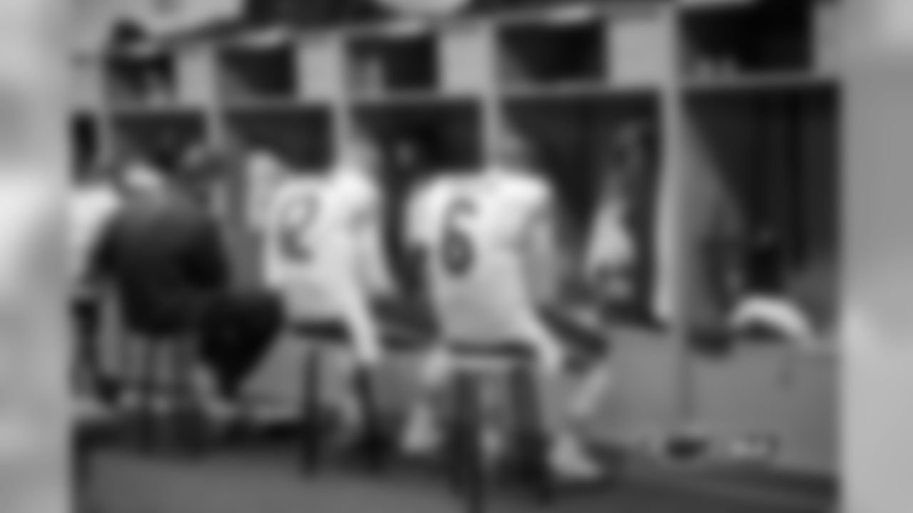 Quaterbacks Jay Cutler (R), Josh McCown (C), and Jordan Palmer (L) review the Bears playbook at their lockers.
