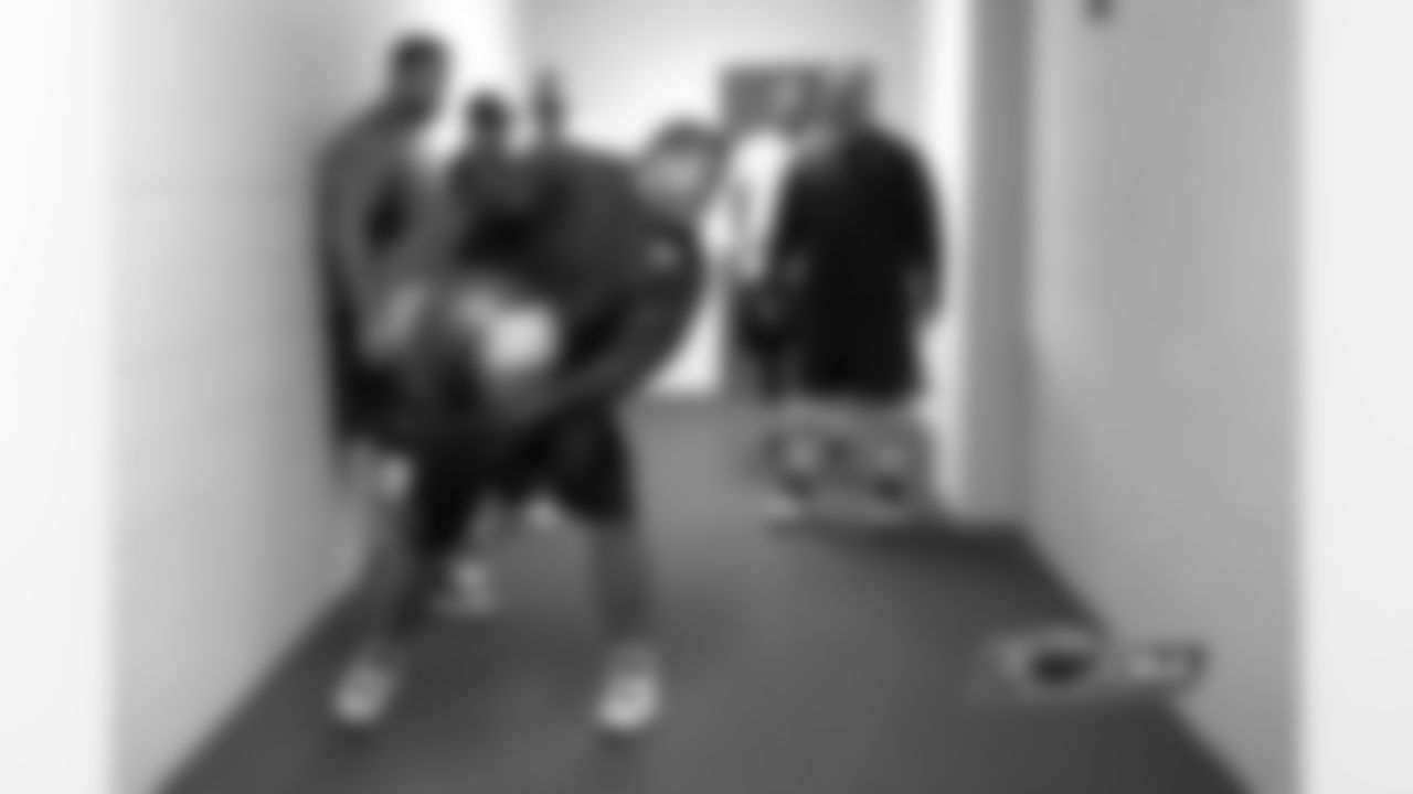 Center Roberto Garza showcases his strength before the game by heaving a medicine ball against the wall and catching it.