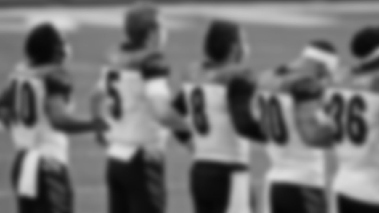 Cincinnati Bengals players hold onto each other during the National Anther before an NFL football game against the Miami Dolphins, Sunday, Dec. 6, 2020, in Miami Gardens, Fla. (AP Photo/Lynne Sladky)