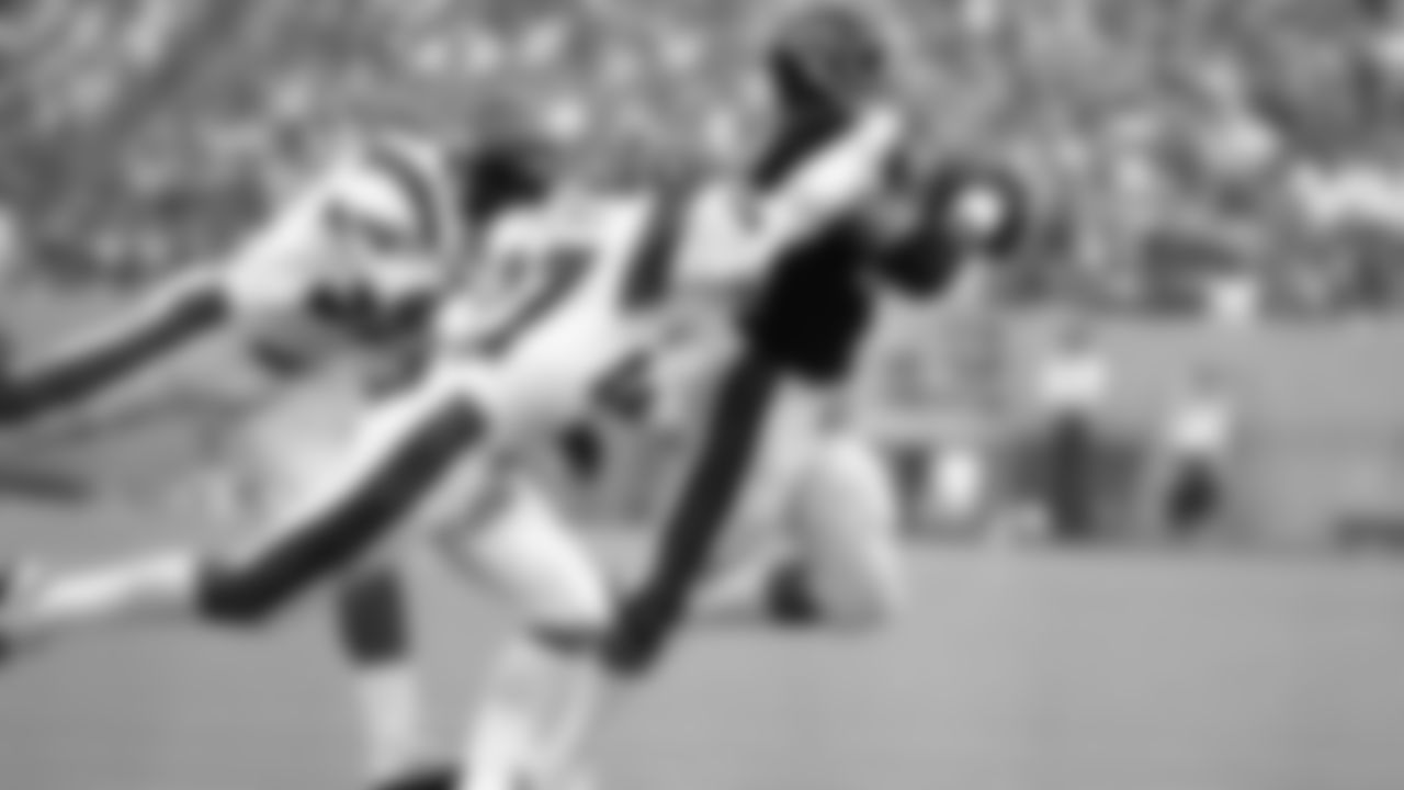 Chicago Bears halfback Walter Payton takes in a pass from Vince Evans in full stride and tries to out race Bengal defenders Bryan Hicks and Reggie Williams.