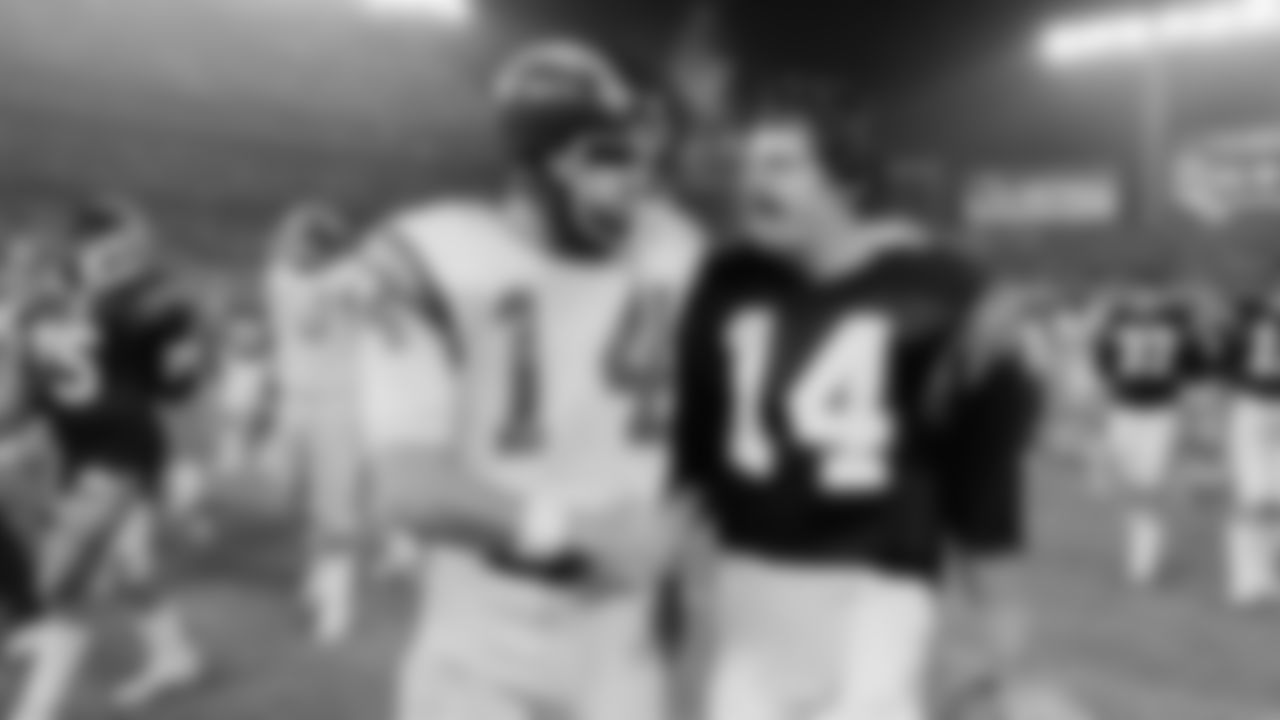 San Diego Chargers' quarterback Dan Fouts (14), left, receives congratulations from Cincinnati Bengals quarterback Ken Anderson after the Chargers defeated the Bengals, 50-34, in San Diego, Dec. 21, 1982. The teams set an NFL record by combining for 851 yards in total passing. (AP Photo)