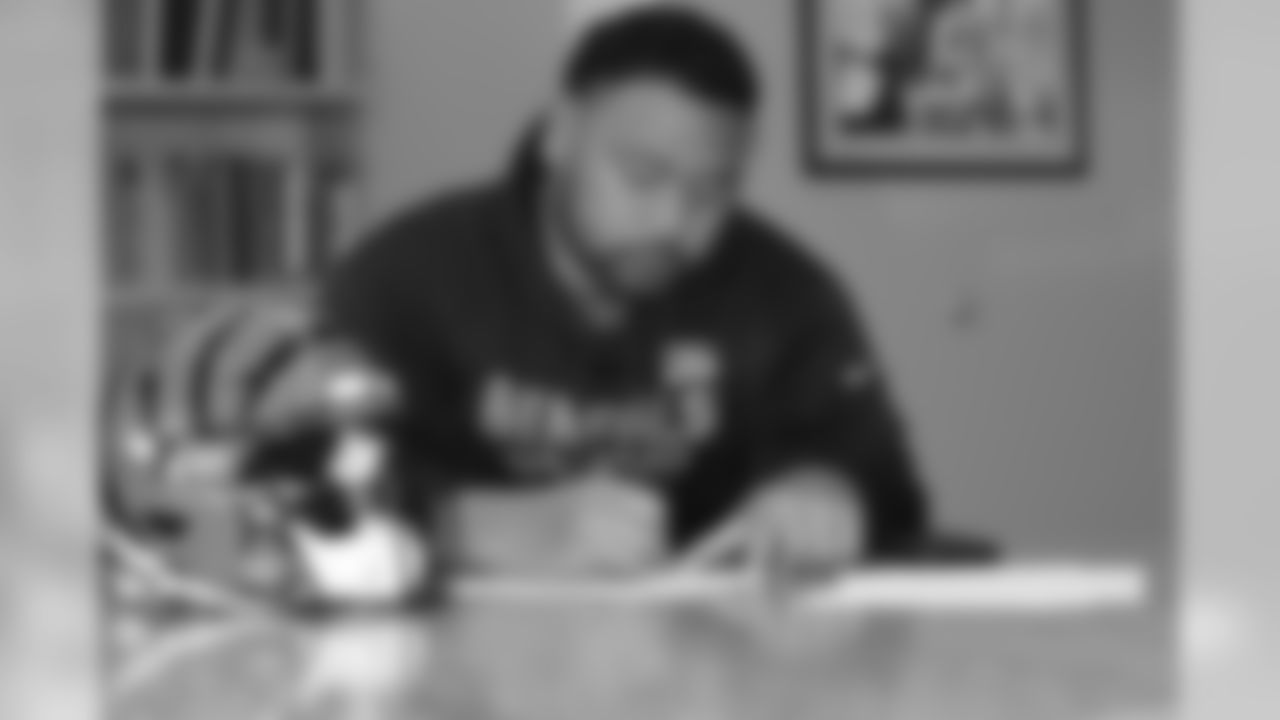 Bengals defensive tackle Josh Tupou signs his contract at Paul Brown Stadium.