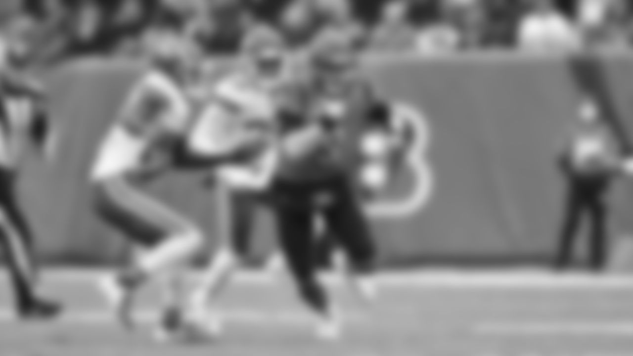 Quarterback Joe Burrow escapes the Kansas City Chiefs pass rush and carries the ball forward.