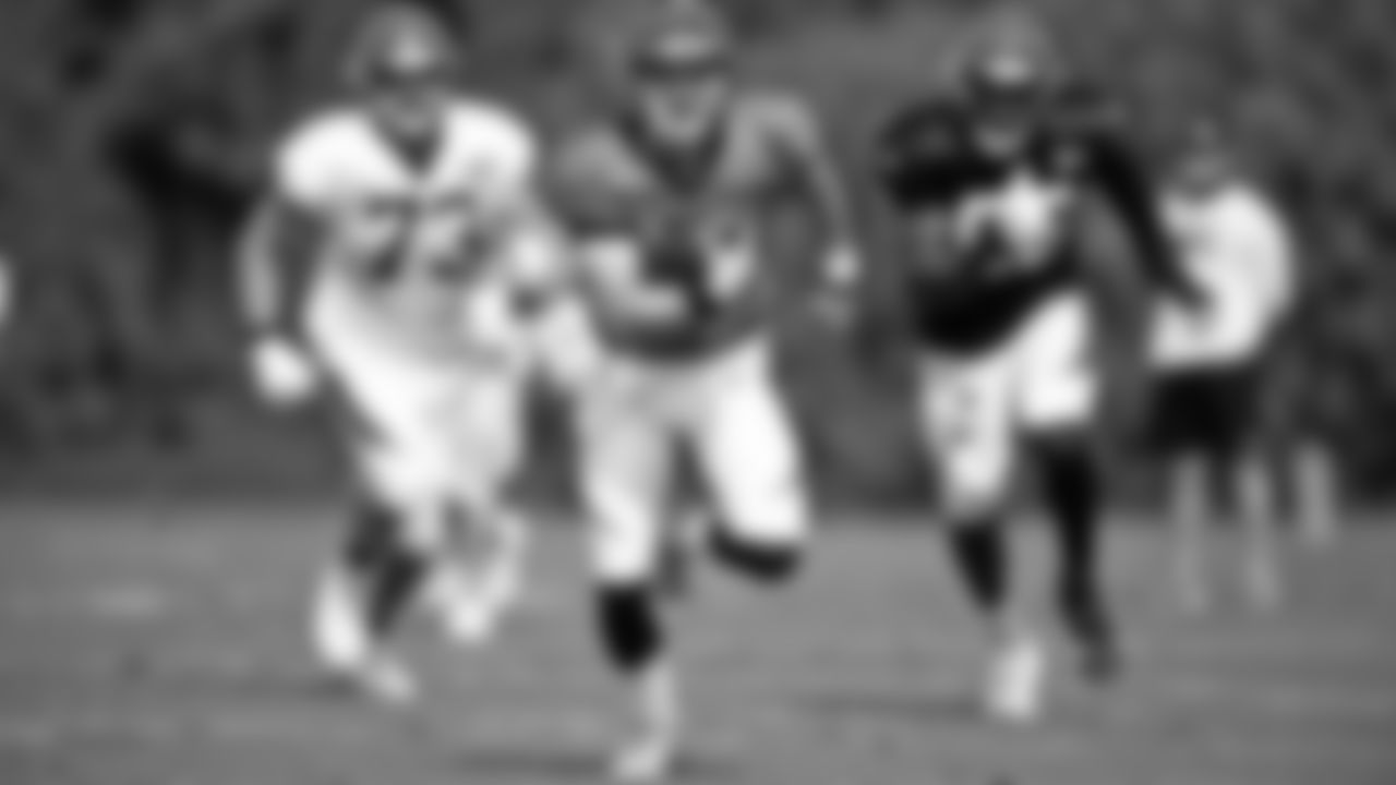 Quarterback Joe Burrow rushes the ball upfield during the team's first scrimmage.