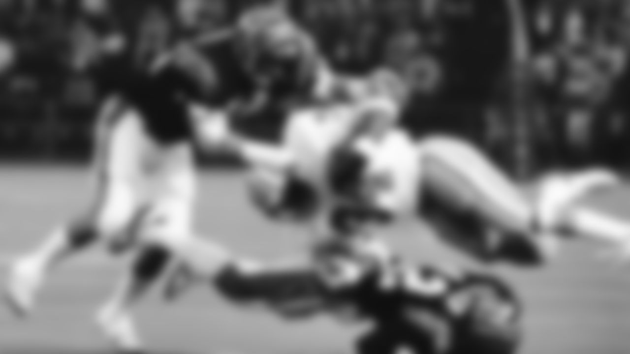 Houston Oilers' running back Earl Campbell is leveled by Cincinnati's Mike Fuller (42) after picking up six yards around his left end in the first quarter of the NFL game, Jan. 2, 1983 in Houston. Bengals' Glenn Cameron (50) pounces on Campbell to make sure of the stop. (AP Photo/Ed Kolenovsky)