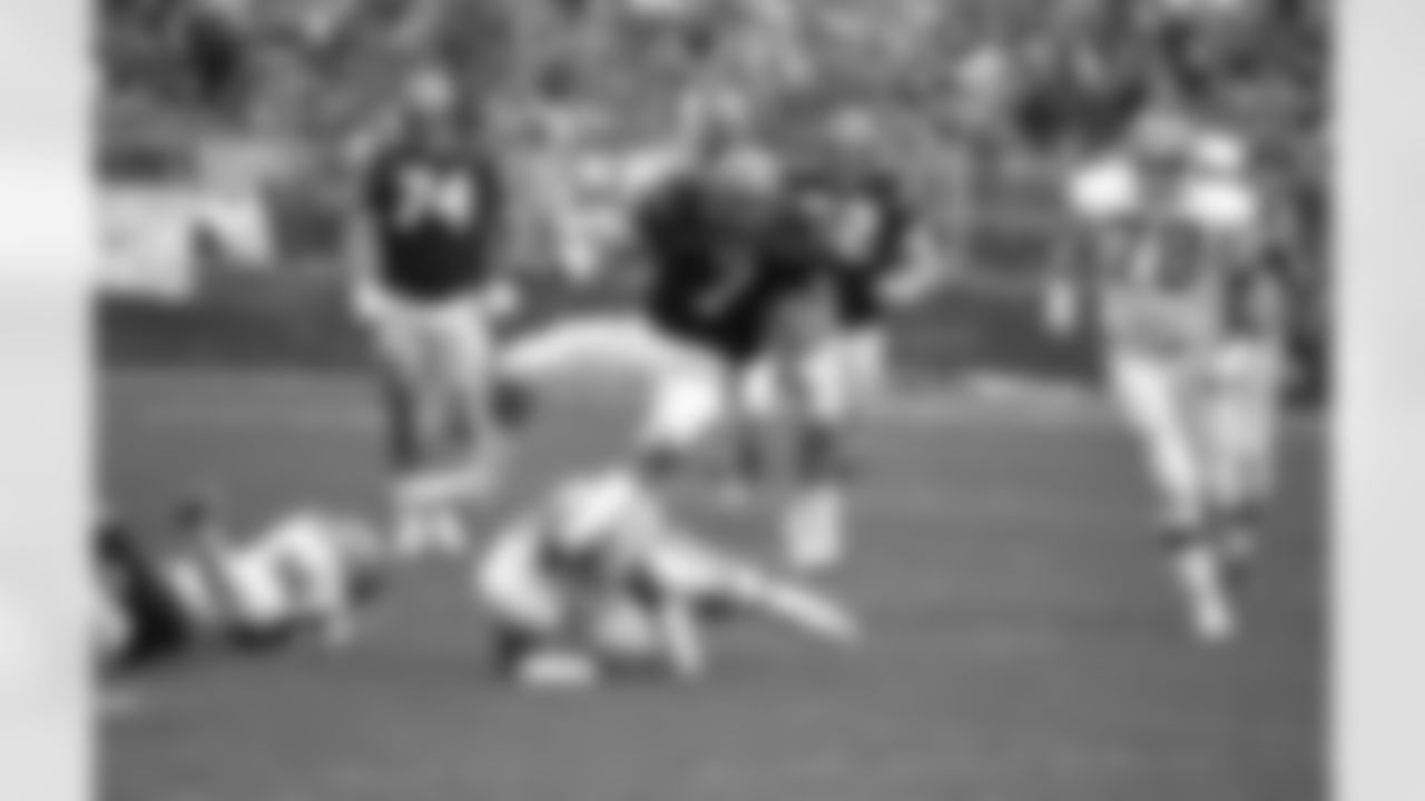 Cincinnati Bengals quarterback Boomer Esiason (7) is tripped up by Cleveland Browns linebacker Eddie Johnson late in the 2nd quarter of 24-6 Browns win in Cleveland, Nov. 25, 1985. Esiason left the game after the play with a hip pointer and didn't return as Cleveland evened their record at 6-6. (AP Photo/Joe Glick)