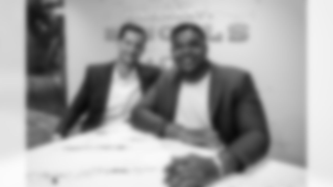 Michael Portner of Delta Sports Group(Left) and Bengals free agent signee Orlando Brown Jr. smile as Brown Jr. signs his contract on March 17, 2023.
