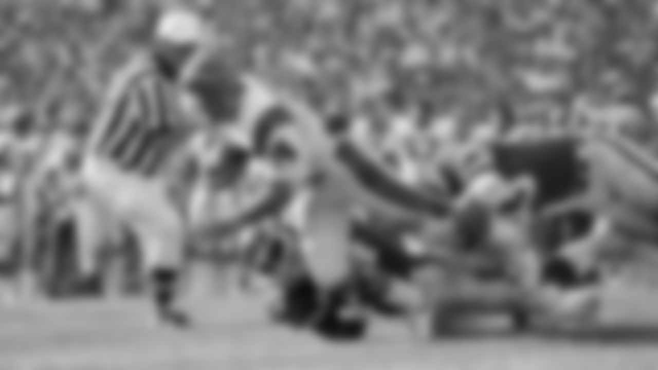 The Cincinnati Bengals quarterback Ken Anderson (14) is stopped during the second quarter by the New York Jets' Abdul Salaam (74) and Marty Lyons (93) in New York on Sept. 13, 1981. (AP Photo/G. Paul Burnett)
