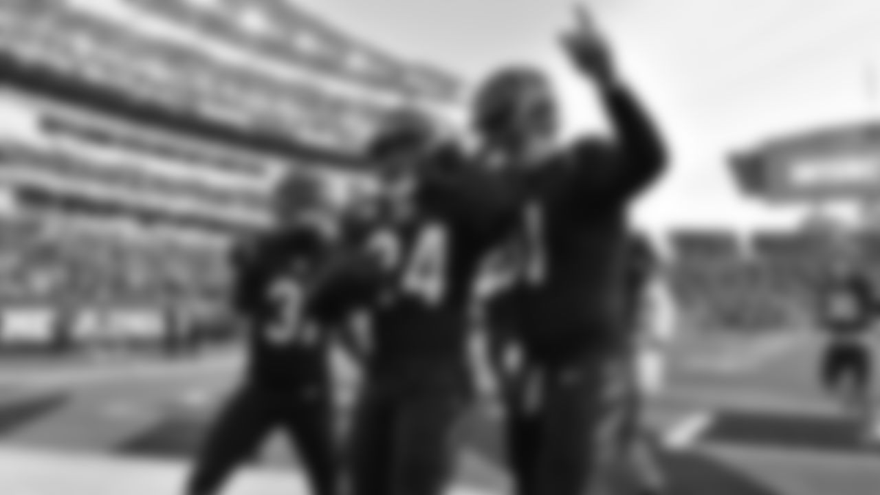 Vonn Bell celebrates with teammates in the end zone after recording an interception of Ravens quarterback Josh Johnson.
