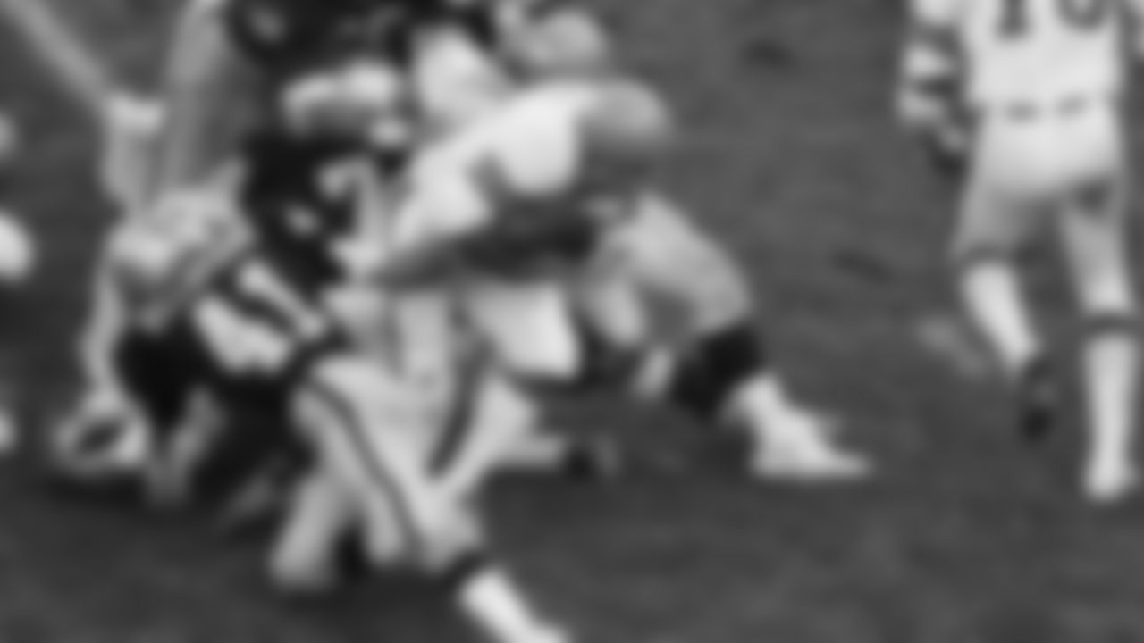 Lenvil Elliot of the Cincinnati Bengals, left, goes up the middle for six yards and a touchdown in the third period of AFC Playoff game against the Oakland Raiders at Oakland, Calif., Dec. 28, 1975. Others are unidentified. (AP Photo)