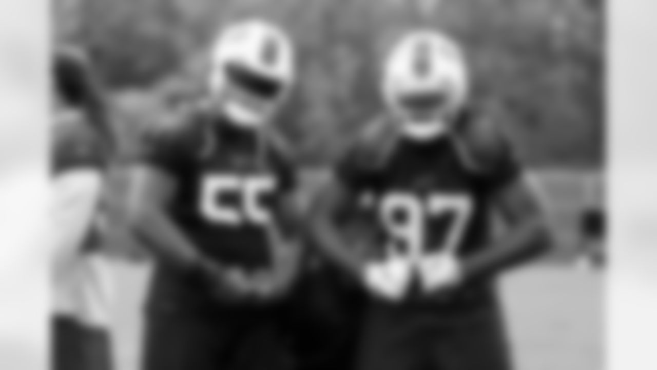 Jerry Hughes (55), Laura Young, and Mario Addison (97) pose for the camera. Buffalo Bills Week 6 practice, October 15, 2021. Photo by Ben Green