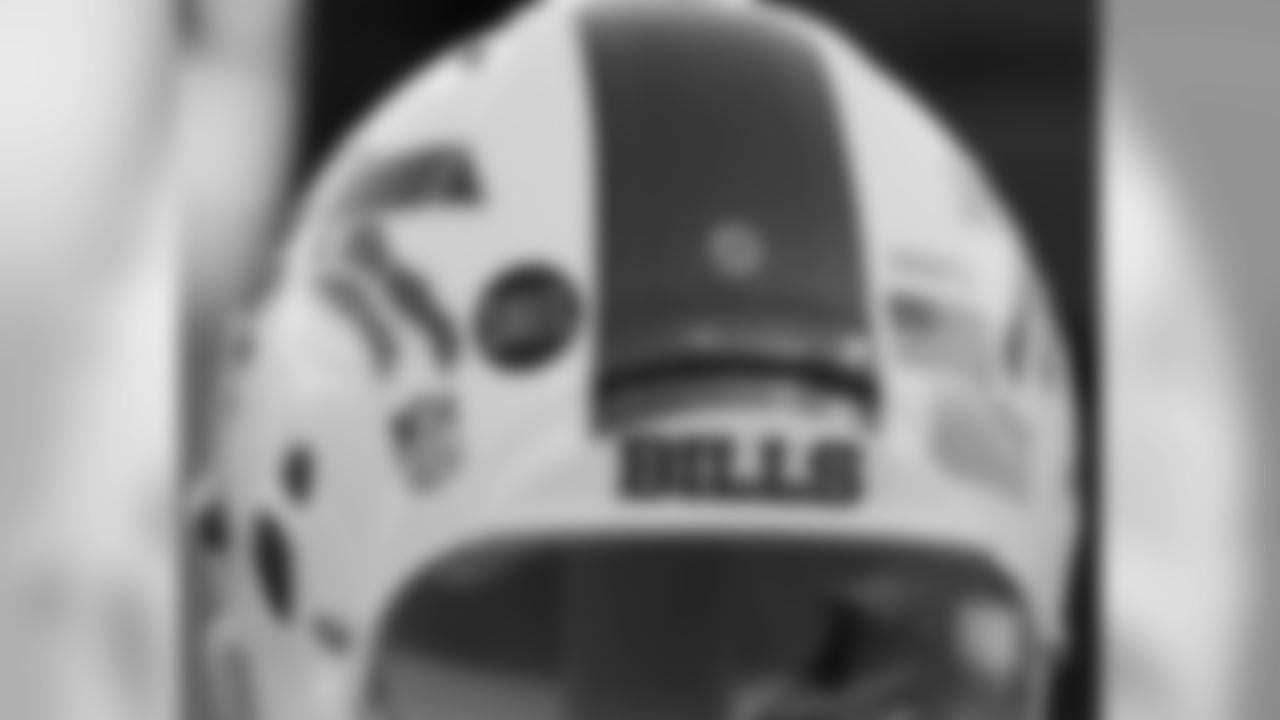 A Buffalo Bills helmet displays a WWFD (West Webster Fire Department) decal in memory of two fallen West Webster, N.Y., firefighters who lost their lives in a shooting on Dec. 24 and a S.H.E.S. decal in honor of the victims of the Sandy Hook Elementary School shootings on Dec. 14 before an NFL football game against the New York Jets on Sunday, Dec. 30, 2012, in Orchard Park, N.Y. (AP Photo/Gary Wiepert)
