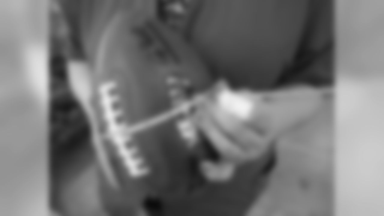 Inspector Micki Adams measures one of the official game balls for the NFL Super Bowl XLIV. The game balls must all measure 28 inches end to end, 21 inches around the middle, and weigh between 14 and 15 ounces.