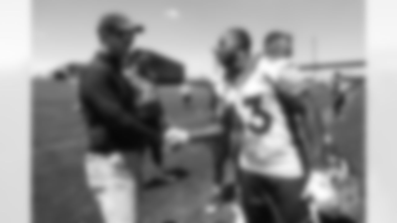 Joe Jones greets former Broncos quarterback Peyton Manning after the Broncos' practice on the eight day of their OTAs on May 30, 2019.