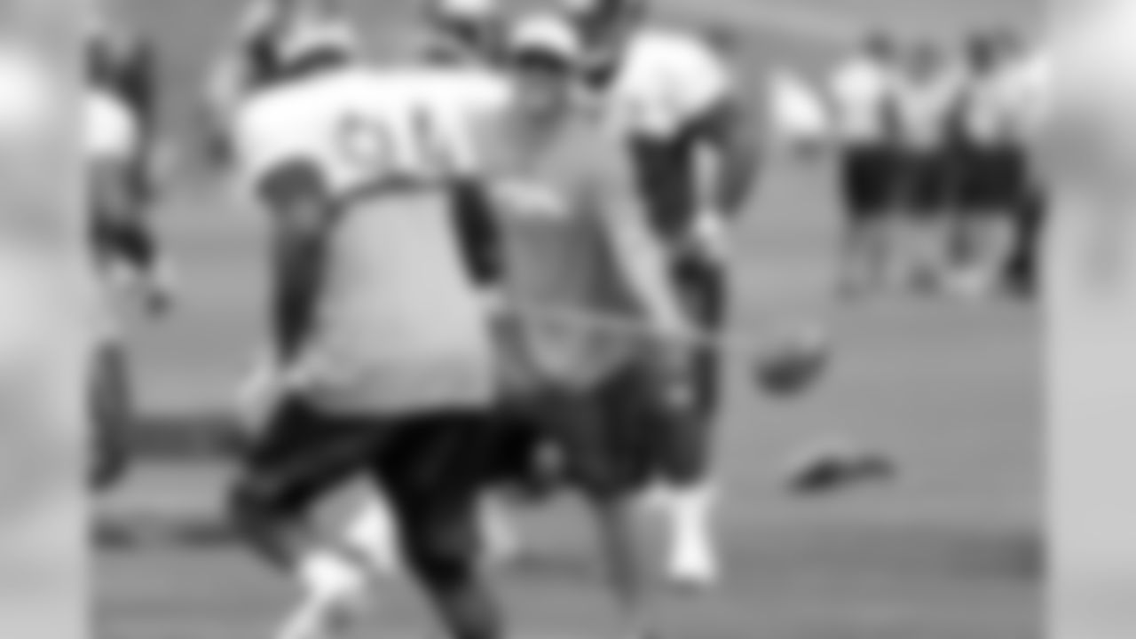 Rodgers holds the ball for DeMarcus Ware as the defensive line practices strip-sacking the quarterback.