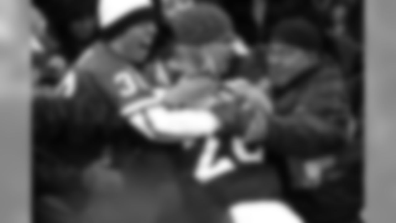 Clinton Portis celebrates with the fans and his teammates after rushing for a touchdown against the Kansas City Chiefs at Invesco Field at Mile High in Denver, CO on December 15, 2002.
