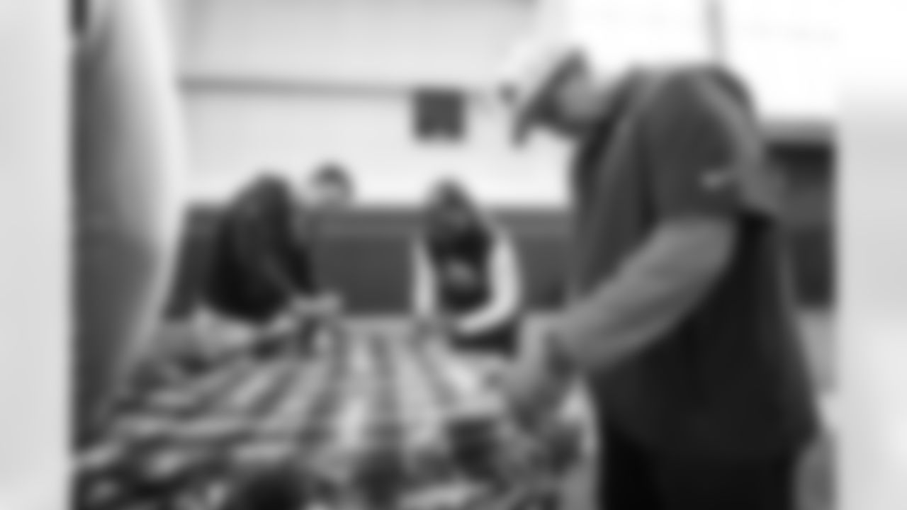 Senior Defensive Assistant Dom Capers, Defensive Backs Coach Christian Parker and other coaches and staff members help make blankets for children as part of Denver Day of Service activities at UCHealth Training Center in Englewood, Colorado on June 3, 2022. (Photo by Ben Swanson)