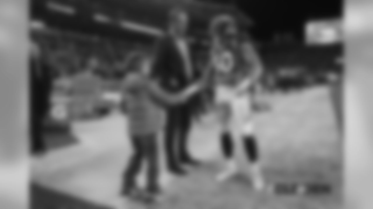Phillip Lindsay talks with Peyton Manning and his son Marshall before the Broncos' Week 15 game against the Cleveland Browns at Broncos Stadium at Mile High on December 15, 2018.