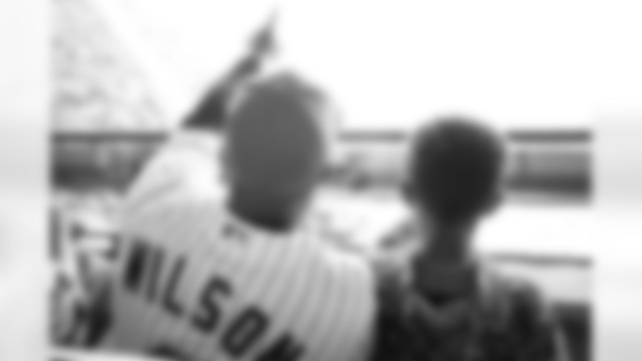 Russell Wilson points to the field as he talks with his son Future during his visit to the Colorado Rockies' Opening Day game at Coors Field in Denver, Colorado on April 8, 2022. (Photo by Ben Swanson)