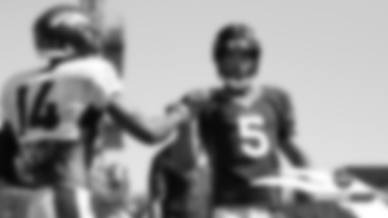 Joe Flacco fist-bumps Courtland Sutton after a completion during practice on Day 4 of training camp on July 21, 2019.