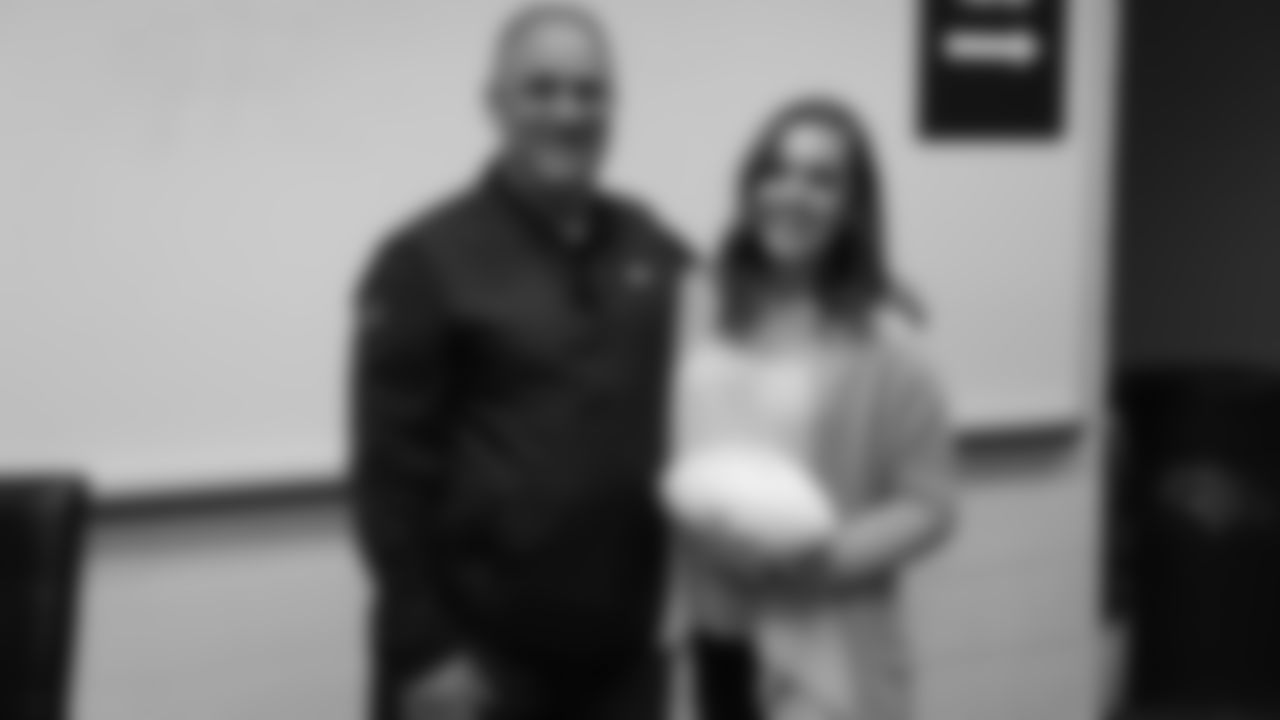 Head Coach Vic Fangio poses for a photo with a raffle winner at a meet-and-greet visit with team employees at Broncos Stadium at Mile High on March 19, 2019.