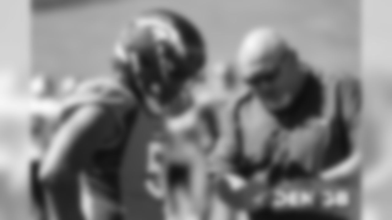 Todd Davis talks with Linebackers Coach Reggie Herring during the Broncos' practice on September 20, 2019.
