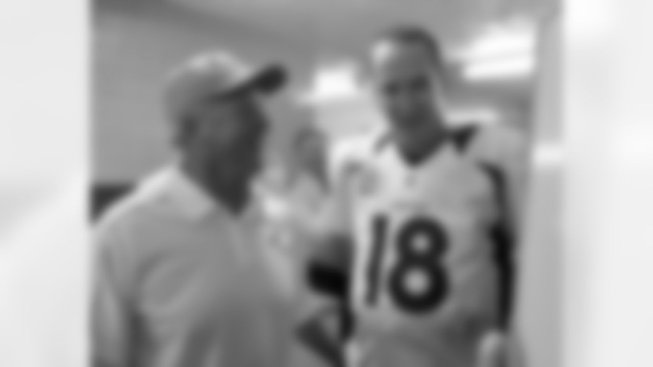 The coach and quarterback celebrate together in the locker room.